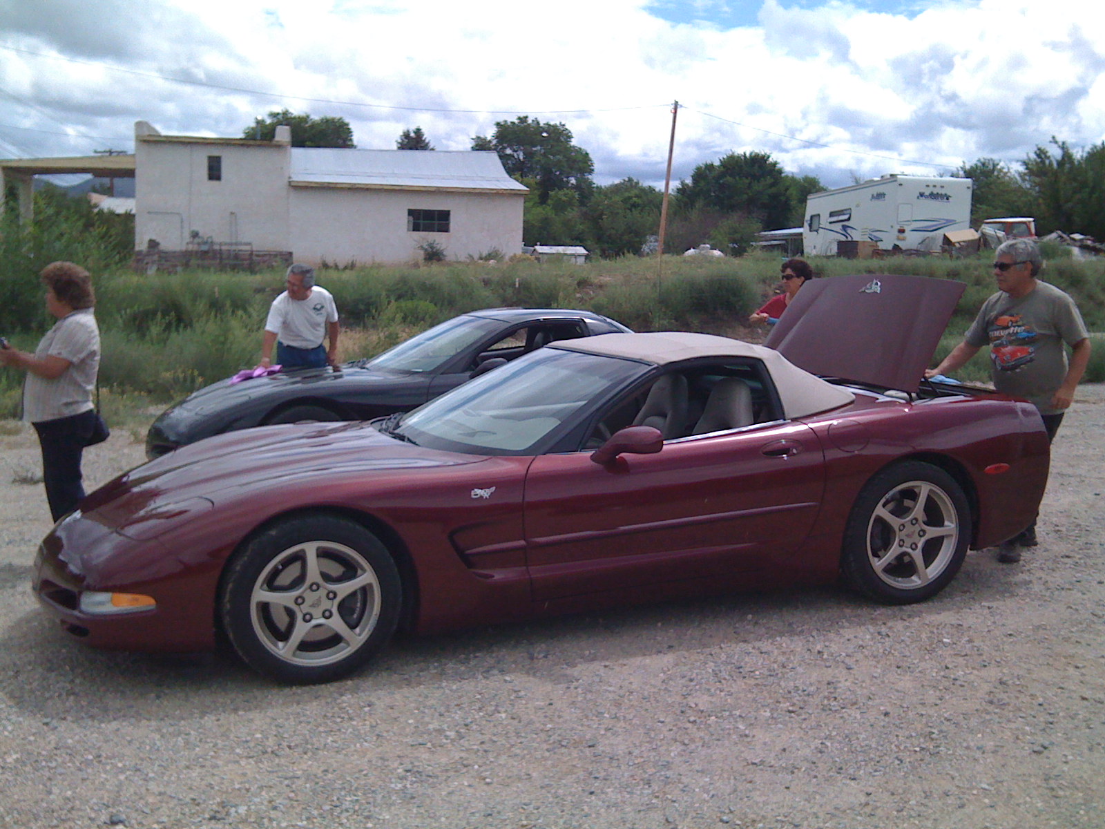 Larry standing beside his 2003 Corvette convertible at a gathering