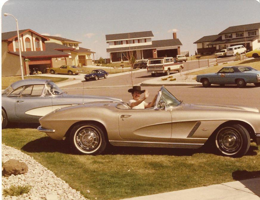 Larry sitting behind the wheel of a silver 1962 Chevrolet Corvette