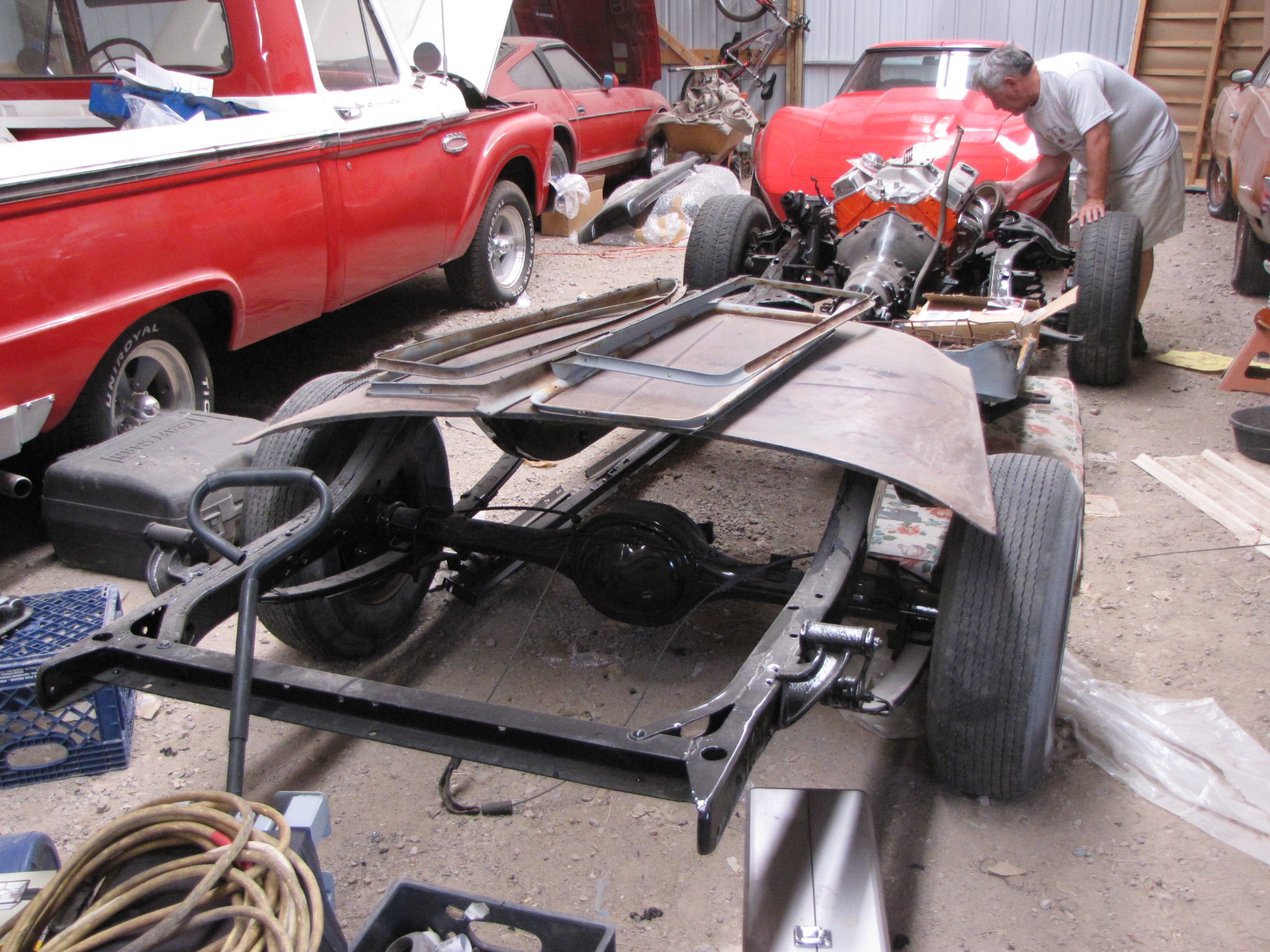 Larry working beside the restored chassis and drivetrain